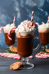 Glass cups of tasty cacao with candy canes and marshmallows on table