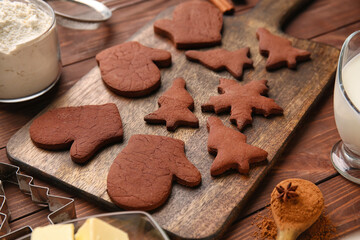 Board with tasty chocolate Christmas cookies on wooden background