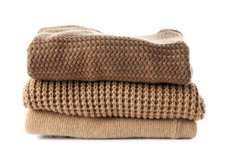 Stack of soft modern sweaters on white background