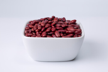 red kidney bean in white bowl on white background studio shot