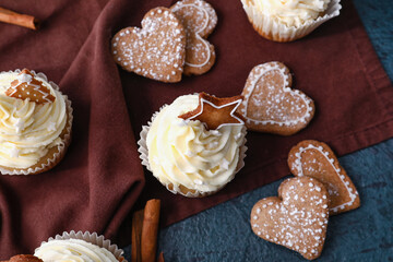 Delicious Christmas cupcakes and cookies on black background