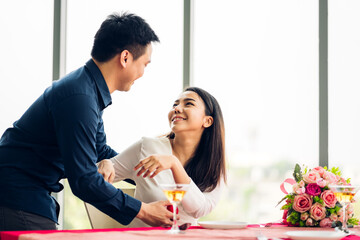 Young handsome man giving ring for surprise to girlfriend and talking together in valentine day at the restaurant