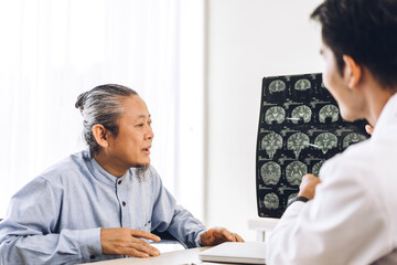 Asian man doctor wearing uniform with stethoscope help support discussing and looking at chest x-ray film photo of asian senior man patient with brain.healthcare and medicine