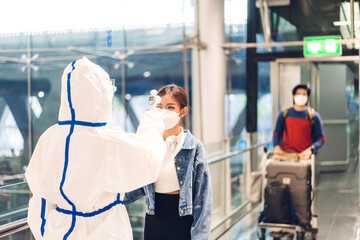 Doctor woman use infrared forehead thermometer for check body temperature scan travel passenger fever in quarantine for coronavirus omicron wearing safety mask at International terminal airport.