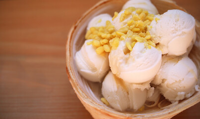 Coconut Milk Ice Cream in the coconut shell on wooden table background. Thai dessert concept.