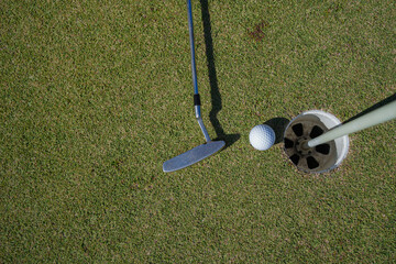 Obraz premium Golf ball and golf club on green in the evening golf course with sunshine in thailand.