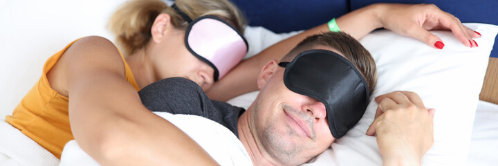 Hugging man and woman with sleep mask sleeping bed