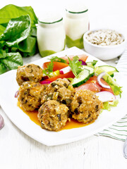 Meatballs with spinach and oatmeal on table