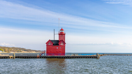 Big red light house in Holland, Michigan at the coast line of lake Michigan