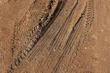 Tyre track on dirt sand or mud, Picture in retro or grunge tone. Car drive on sand. off road track. Track on grass field. Track in farm.