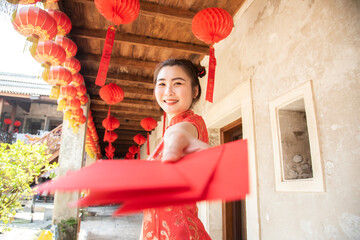 Chinese woman dress traditional cheongsam dress holding red envelopes hong bao. Chinese new year concept.