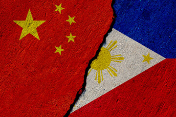 chinese and philippines flags painted on cracked concrete wall, china and philippine conflict or...