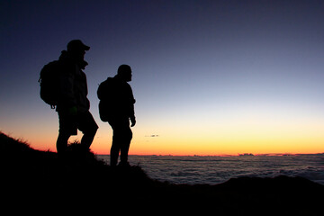 Silhouette of 2 Hikers in the Mountain with a Sea of Clouds