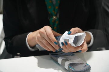 Almaty, Kazakhstan - 11.16.2021 : The cashier of the bank holds in his hands new banknotes of Kazakhstani tenge