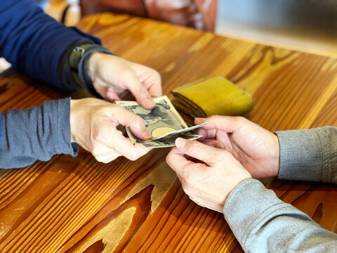 女性にお金を渡す女性の手