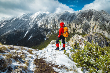 Hiker woman enjoying the view from the snowy mountain ridge