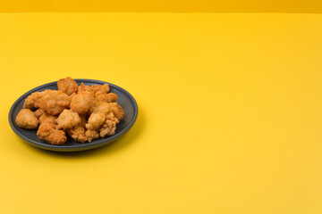 A plate of fried chicken with yellow background
