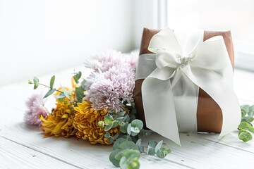 Close up of festive gift box and chrysanthemum flowers.