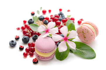 A scattering of juicy berries, flowers and macarons.