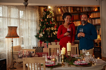 Diverse couple toasting with red wine during Christmastime