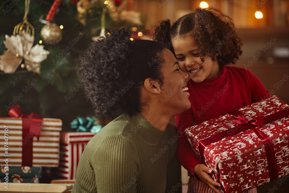 Wall mural little african girl received christmas gift from mother