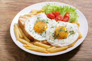 Breakfast with plate of fried eggs, toasts and french fries