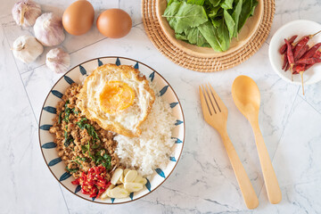 Traditional Thai street food, top view stir fried minced pork with basil, chili and garlic, serve with fried egg