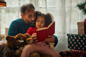 Father and daughter reading a book - Powered by Adobe
