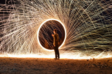 Iron wool circle drawing light fireworks. Burning Steel Wool spinning, Trajectories of burning sparks at night. Movement light effect, steel wool fire hoop. long exposure light painting, Pyrotechnic