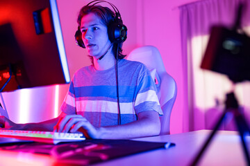 young  playing game online at home. Gamer  controlling joystick for video game. Teenage girls leisure game in neon light room at home.