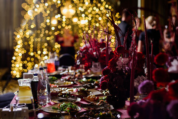 Сatering table with food, flowers and glass stemware at restaurant before party 