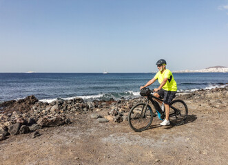 Senior man outdoors biking at sea enjoying freedom and healthy lifestyle