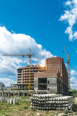 Extensive scaffolding providing platforms for work in progress on a new apartment block,Tall building under construction with scaffolds,Freestanding tower crane on a building site
