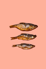 Three dried fishes on pink background, pop art style