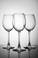 Three of empty glasses on a black table with a reflection