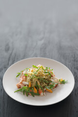 Fettuccine pasta with crab and arugula on black wood table