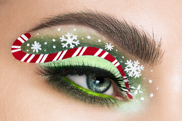 Eye girl makeover snowflakes and candy cane. Beauty winter christmas makeup. Eyelashes. Cosmetic...