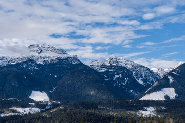 Fototapeta na wymiar panorama of high mountains covered by snow cloudy blue sky british columbia canada