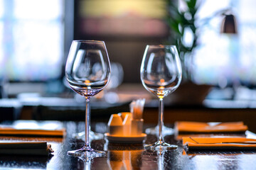 empty wine glasses on a large served table in warm light
