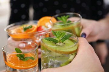 People holding cooling drinks cocktails and make clink with glasses, cheers or toast