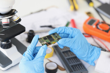 Technician hold component of digital device, repair smartphone at home