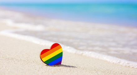 LGBT heart on the sandy beach against the background of the sea. Concept of the best resort for lgbt couples