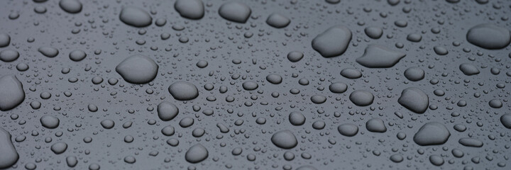 Closeup of raindrops on dark glass background