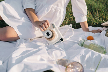 Fototapeta premium The film camera lies on the picnic tablecloth