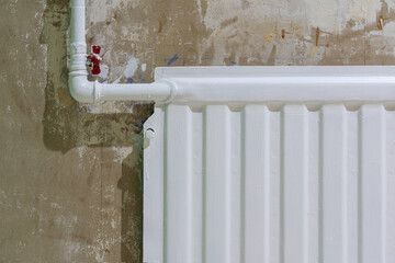 Fragment of an old plasterboard room wall during renovation. The surface is smeared with paint. There is a white heating radiator. Background. Texture.