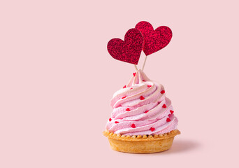 Saint Valentines Day background. Cupcake or tartlet with pink meringue cream decorated with two big...