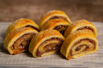 Close-up of homemade filled pastries - cut rugelach cookies. Made with butter and cream cheese doughs filled with apricot, raisins and walnuts.