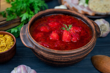 delicious hot red borscht with onion lard and bread. National Ukrainian and Russian food with an hour and sour cream on a wooden background
