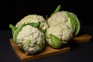Cauliflower on a black background. Delicious and healthy vegetables. Vegetarian food.