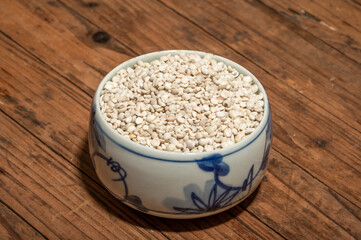 The plate or bowl on the wood grain table contains job's tears